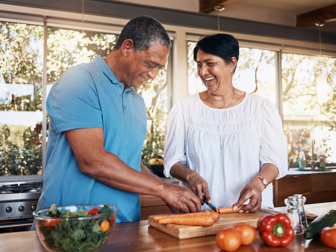 Husband and wife cooking in kitchen